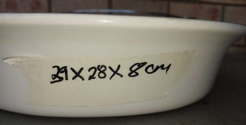 AN OVEN PROOF PORCELAIN CASSEROLE BOWL WITH A STAINLESS STEEL CANDLE STAND WARMER