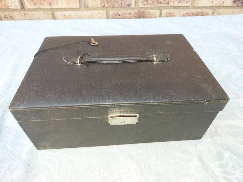 A LARGE BLACK LEATHER BOUND JEWELRY BOX SOLD AS IS