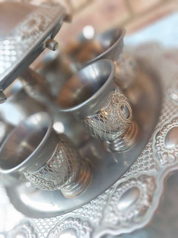A COMPLETE ORNATE SILVER PLATED KIDDUSH CUP SET