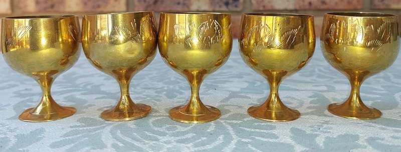 A VINTAGE SET OF FIVE BRASS GOBLETS