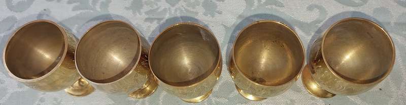 A VINTAGE SET OF FIVE BRASS GOBLETS