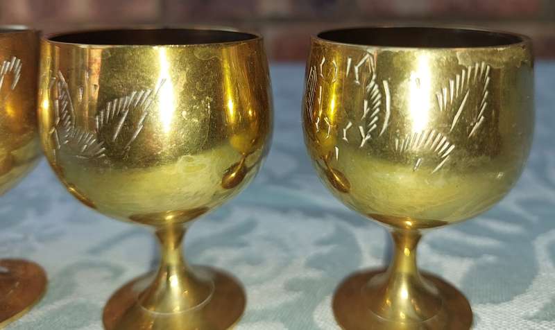 A VINTAGE SET OF FIVE BRASS GOBLETS