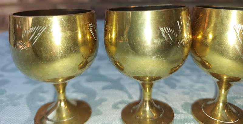 A VINTAGE SET OF FIVE BRASS GOBLETS