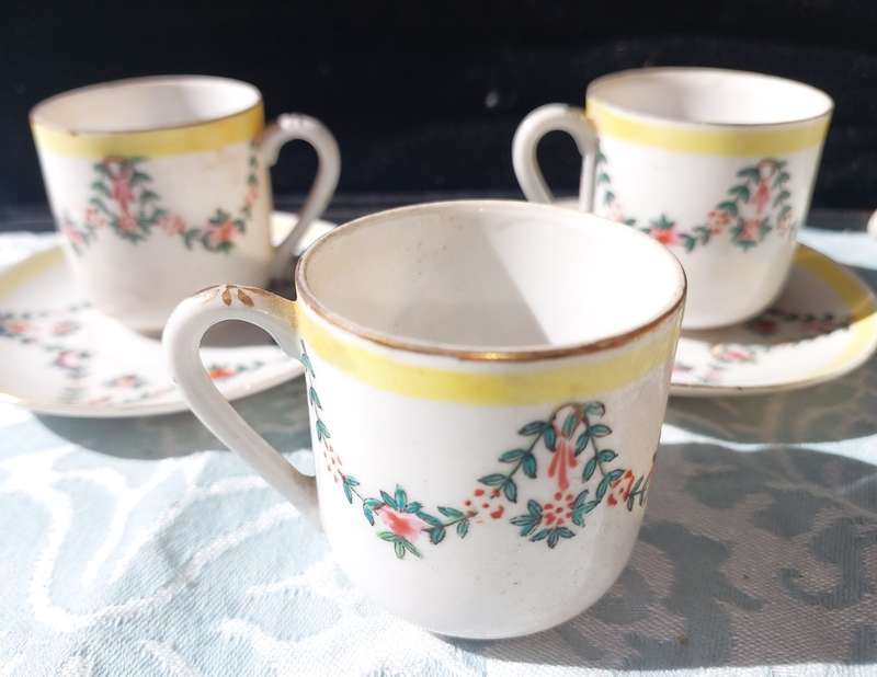 A COLLECTION OF HAND PAINTED TEA CUPS AND SAUCERS