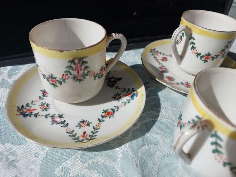 A COLLECTION OF HAND PAINTED TEA CUPS AND SAUCERS