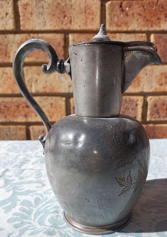 A VINTAGE PUTHAL SILVER PLATED JUG WITH ORNATE ENGRAVINGS