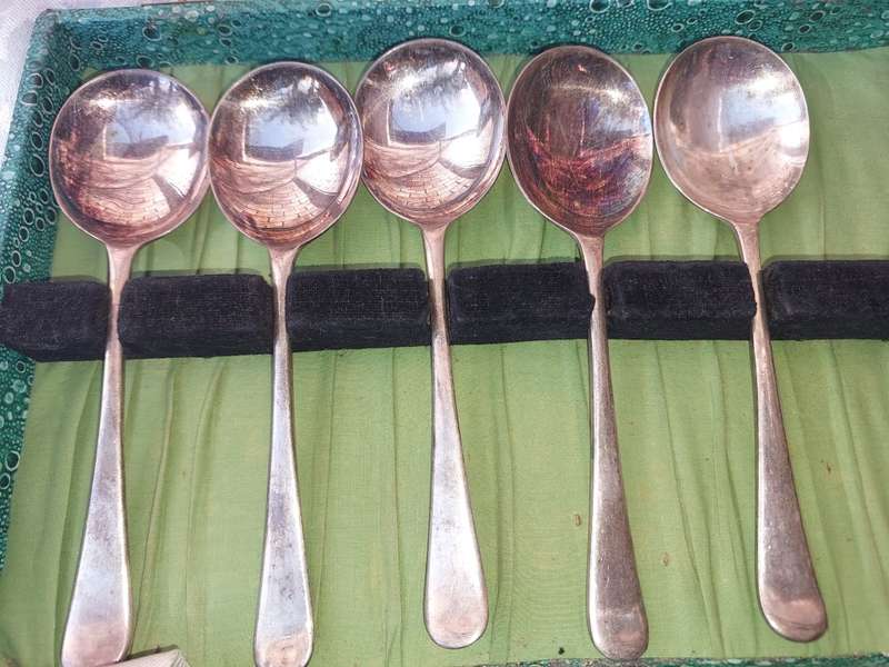 AN ANTIQUE SET OF SPOONS SOLD AS IS