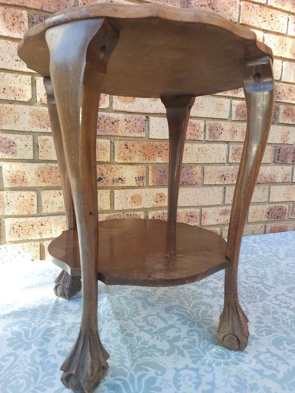 AN ANTIQUE SOLID WOOD TWO TEAR TEA TABLE WITH BALL N CLAW LEGS