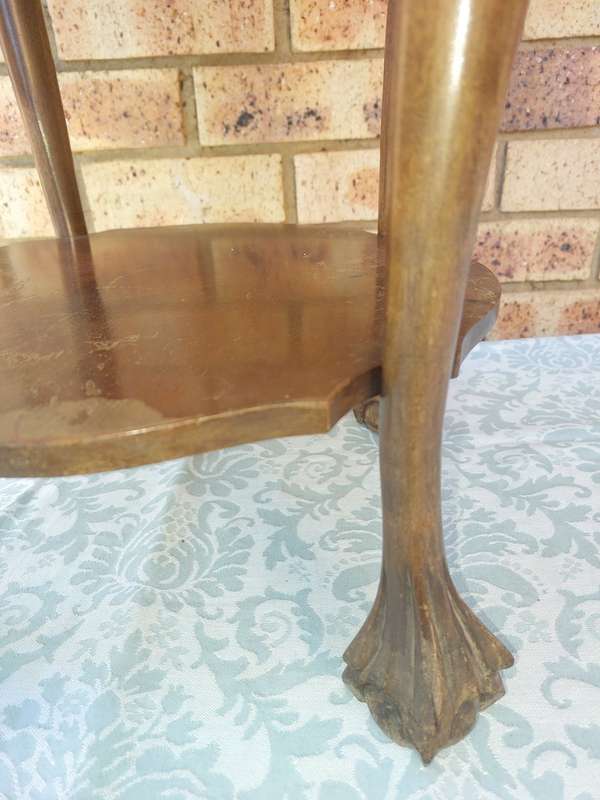AN ANTIQUE SOLID WOOD TWO TEAR TEA TABLE WITH BALL N CLAW LEGS