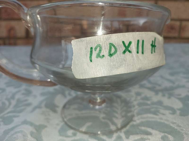 A GLASS SOUCE JUG SOLD AS IS
