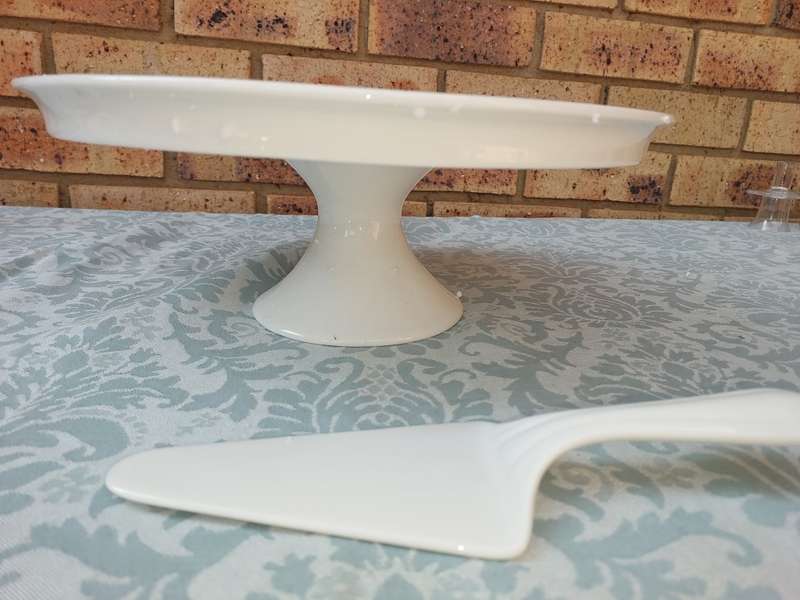 A JUST WHITE PORCELAIN EETRITE FOOTED CAKE STAND AND CUTTER