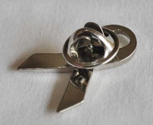 Silver tone ribbon lapel pin with pink stone
