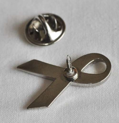 Silver tone ribbon lapel pin with pink stone