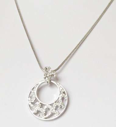 A round pendant on a fleur-de-lis link on a silver tone chain