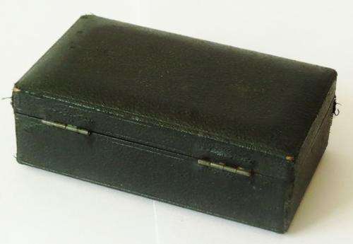 Small antique cast iron pressure gauge with brass plated trim in original case with 3 needles