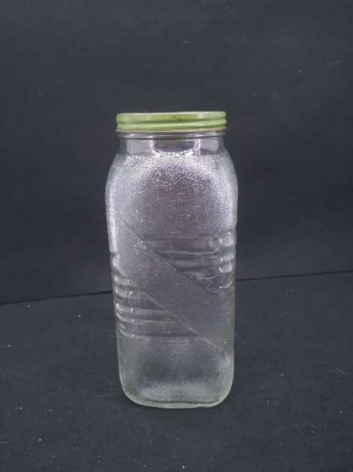 Old glass storage bottle with green tin lid