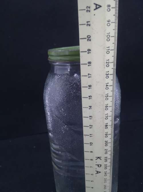 Old glass storage bottle with green tin lid