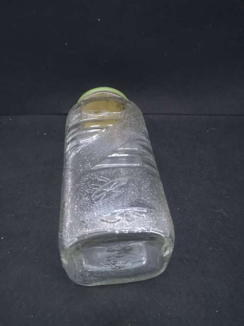 Old glass storage bottle with green tin lid