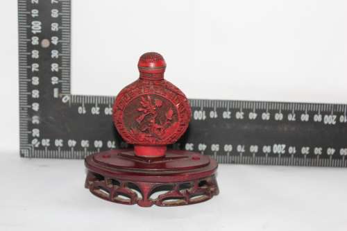 STUNNING CHINESE CINNABAR PORCELAIN SNUFF BOTTLE WITH HAND CARVED WOODEN BASE IN EXCELLENT CONDITION