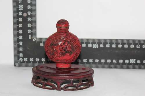 STUNNING CHINESE CINNABAR PORCELAIN SNUFF BOTTLE WITH HAND CARVED WOODEN BASE IN EXCELLENT CONDITION