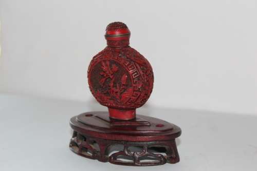 STUNNING CHINESE CINNABAR PORCELAIN SNUFF BOTTLE WITH HAND CARVED WOODEN BASE IN EXCELLENT CONDITION