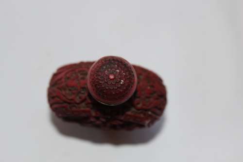 STUNNING CHINESE CINNABAR PORCELAIN SNUFF BOTTLE WITH HAND CARVED WOODEN BASE IN EXCELLENT CONDITION