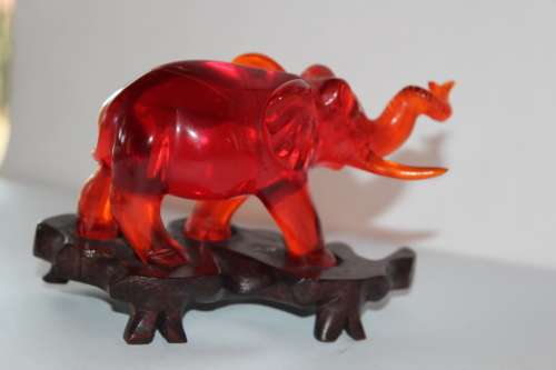 GORGEOUS CHINESE HAND CARVED AMBER ELEPHANT ON CARVED WOODEN BASE CIRCA 1940s 13.5CM LONG