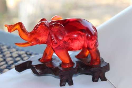 GORGEOUS CHINESE HAND CARVED AMBER ELEPHANT ON CARVED WOODEN BASE CIRCA 1940s 13.5CM LONG