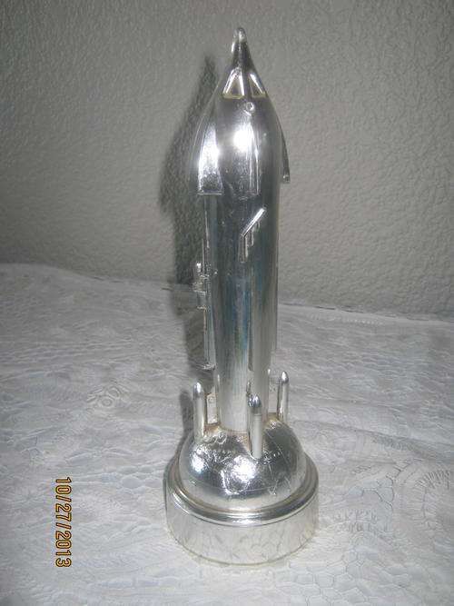 a 1960's spacecraft/ rocket money bank - with coins still inside