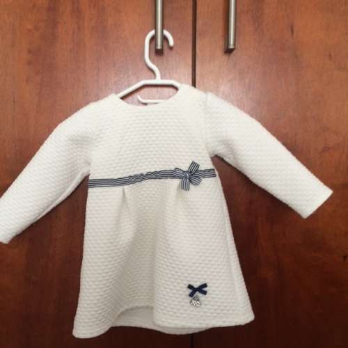 Woollies Babes 6-12 months cream dress with navy / white ribbon detail.