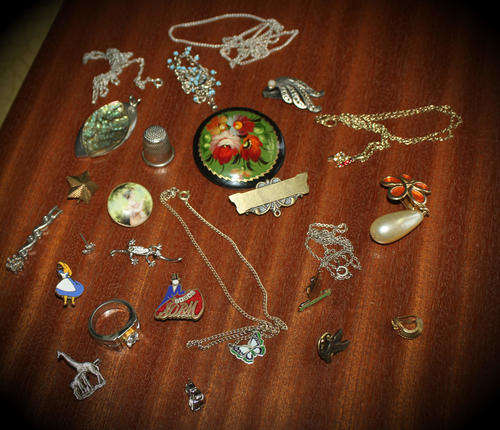 a lot of vintage items -includes badges,brooches chains- jewelry -see photo's