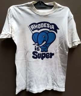 RHODESIA-RHODESIA IS SUPER/I'M BEHIND RHODESIA BLUE ON WHITE T SHIRT (BUSH WAR PERIOD 1970'S)