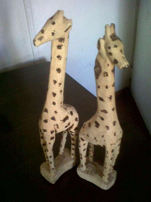 Two tall standing wooden giraffes