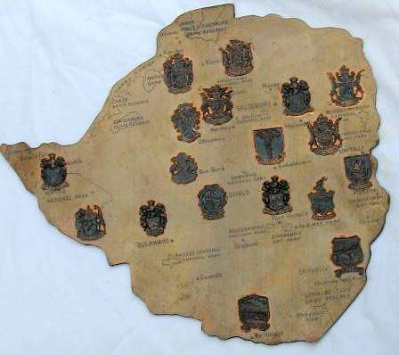 RHODESIA : COPPER MAP MOUNTED ON HARDBOARD : 33X29.5cm :  WITH 18 PLACE BADGES : SOME EDGE DAMAGE