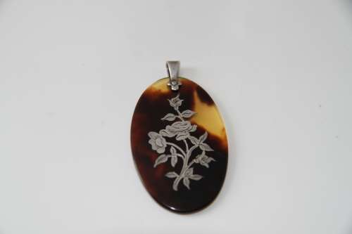 Tortoise shell pendant with sterling silver floral inlay