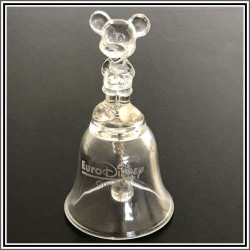 Two small table bells and a glass candle holder.