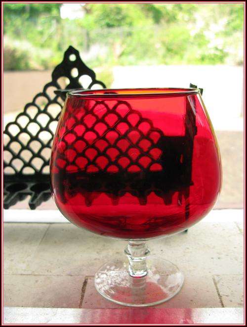 A cognac glass shaped vase stained red. Height 15cm.