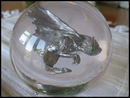 Pewter flying dragon encased in resin ball.