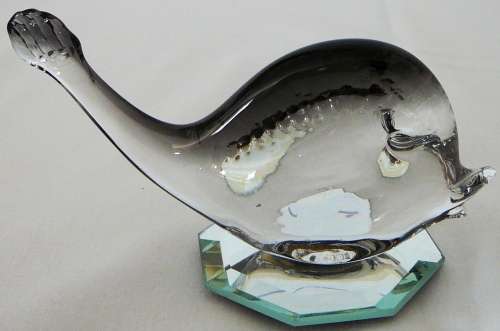 A Murano Glass Whale resting on an Octagonal Mirror