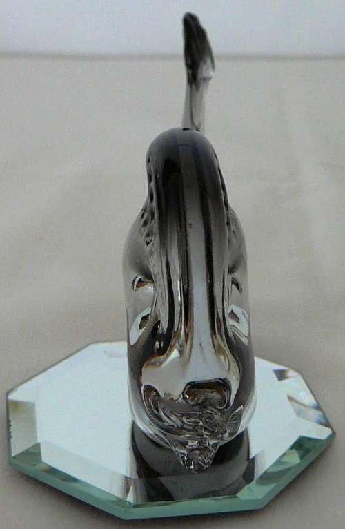 A Murano Glass Whale resting on an Octagonal Mirror