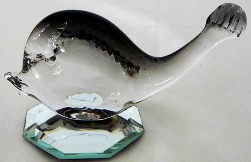 A Murano Glass Whale resting on an Octagonal Mirror