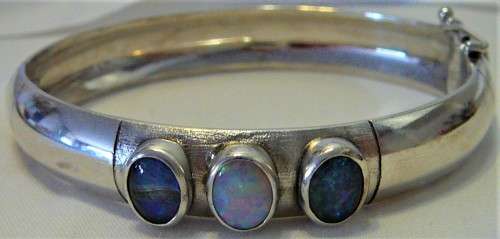 A Very Tasteful Sterling Silver Bangle set with a White Opal & 2 Precious Opals