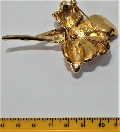 A Gold Coloured Flower Shaped Brooch Encrusted with Numerous Diamantes