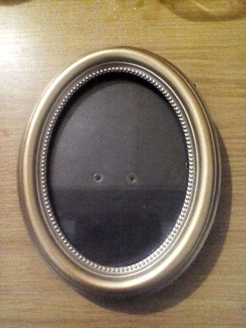 Gilded oval photograph frame with velvet lined easel back.