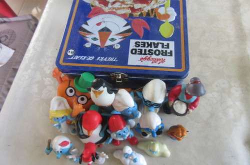 16 HIGHLY COLLECTABLE TOYS IN SLIGHTLY DENTED KELLOGG'S TOASTED FLAKES LUNCH BOX