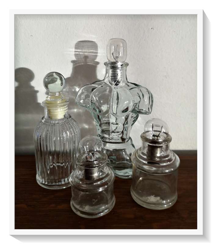 A Collection of Vintage and Contemporary Clear Green Glass Bottles with Fused Lightbulbs as Stoppers
