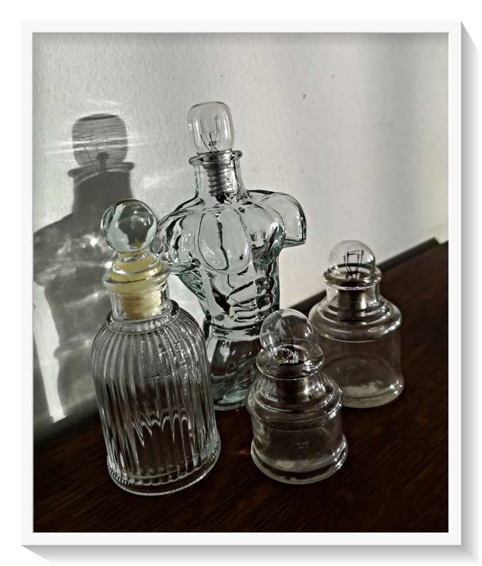 A Collection of Vintage and Contemporary Clear Green Glass Bottles with Fused Lightbulbs as Stoppers