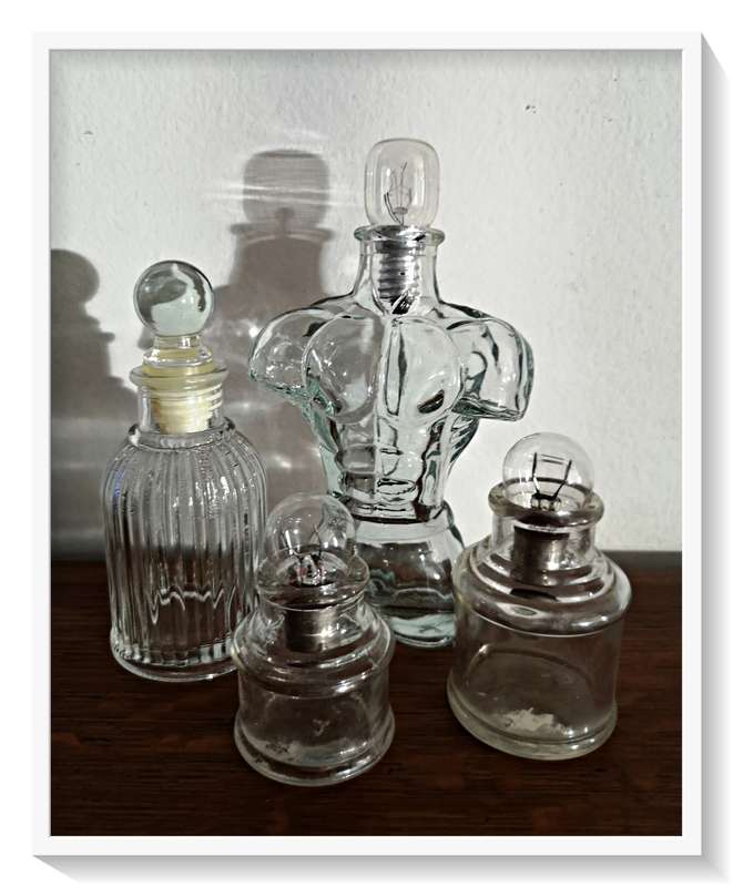 A Collection of Vintage and Contemporary Clear Green Glass Bottles with Fused Lightbulbs as Stoppers