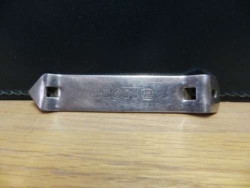 Vintage Bar metal bottle opener marked LION with SAB BADGE.