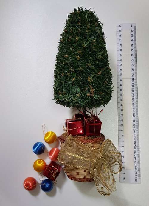Vintage Christmas decoration. Small Christmas tree in basket with gifts under the tree